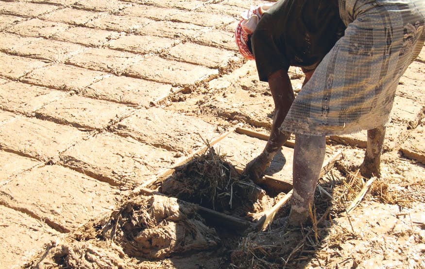 Putting mud mixture into the mould.